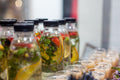 Clear bottles with black caps filled with strawberry, lemon and mint infused water